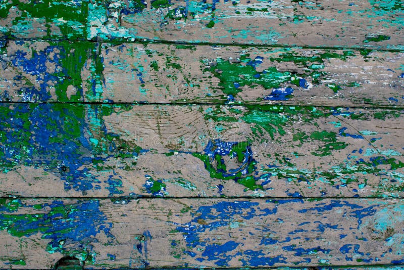 Old building of painted wooden boards with dried green and blue paint stock images